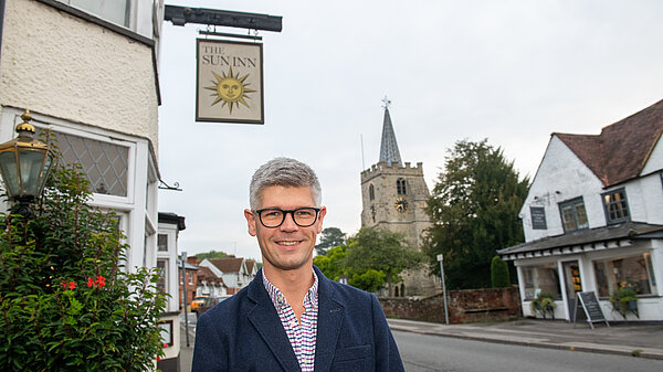 Al standing next to a pub