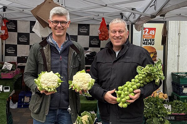 Al standing at a fruit and veg stand in town centre.