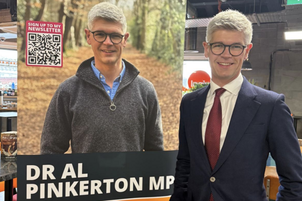 MP standing next to Banner