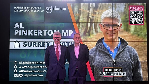 MP standing next to a screen at business talk