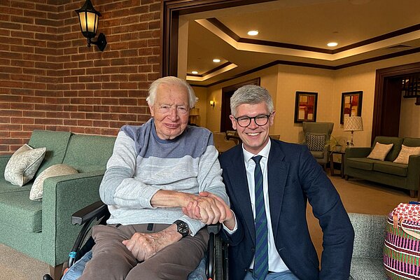 Al shaking the hand of a pensioner.
