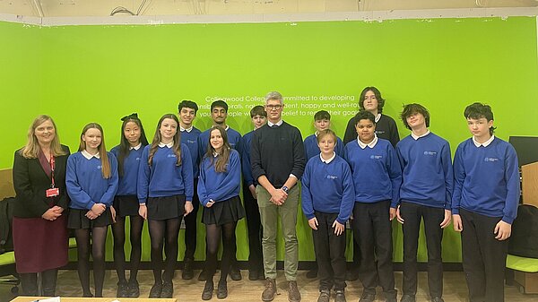 MP standing with secondary school children
